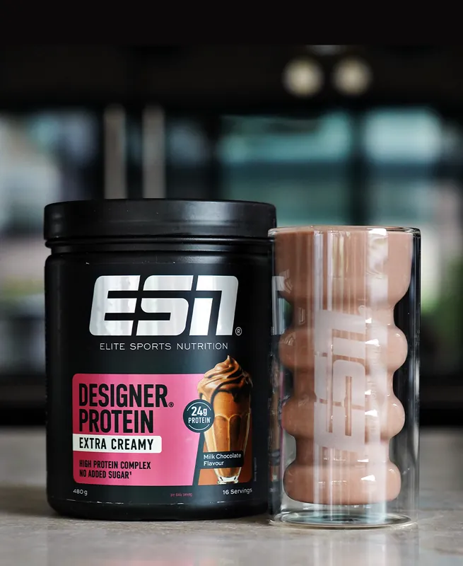 ESN Designer Protein Extra Creamy – Milk Chocolate, ze szklanką